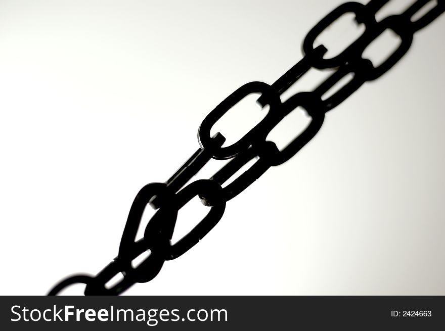 A dark metal chain with light background