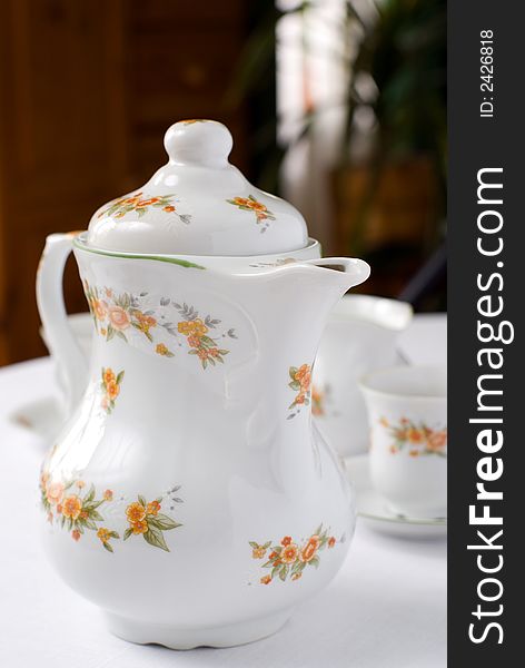 Coffee or tea set on the table - teapot on the front (focus on it) cups and milk jug behind. Shallow DOF. Coffee or tea set on the table - teapot on the front (focus on it) cups and milk jug behind. Shallow DOF.