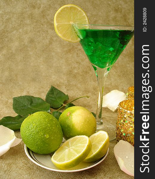 Martini glass with limes on a plate and candles