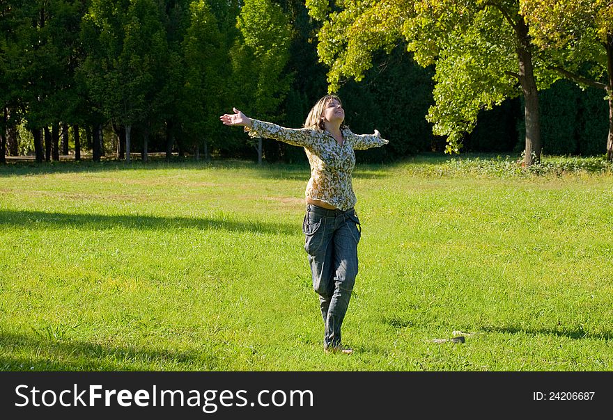 S.Carefree adorable girl with arms out in field.