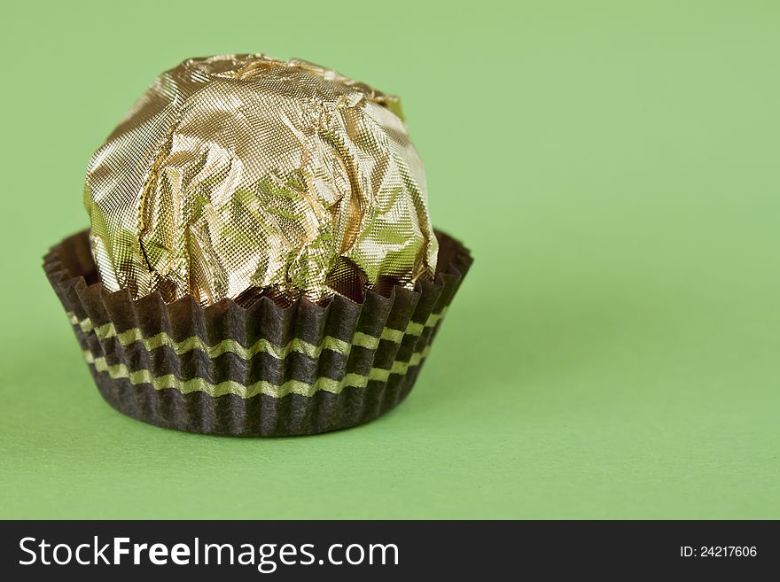 Delicious chocolate filled pralines on green background