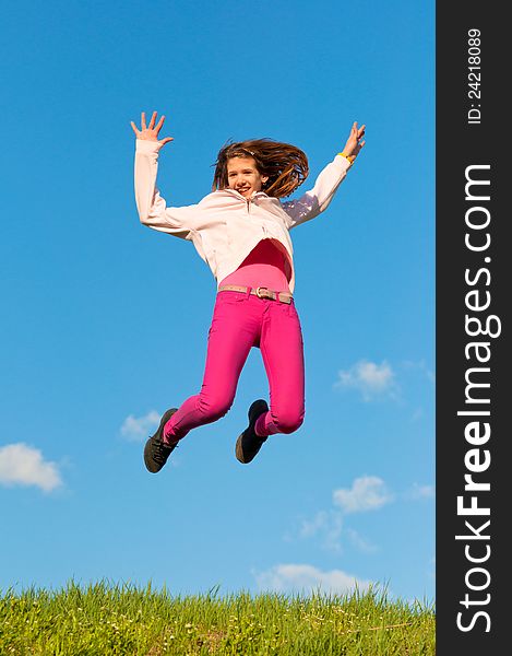 Cute teenage girl jumping with joy on sunny spring day.