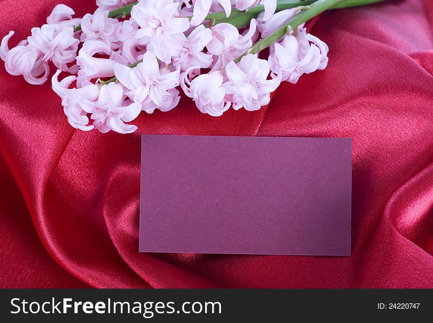 Pink on the red silk giotsint and a card. Pink on the red silk giotsint and a card