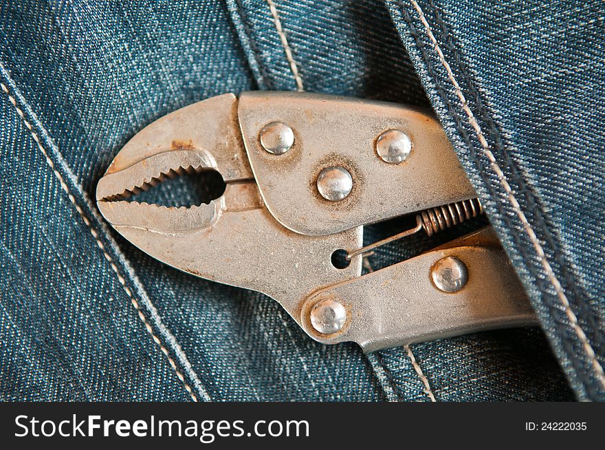 Old lock pliers in jeans pocket. Old lock pliers in jeans pocket
