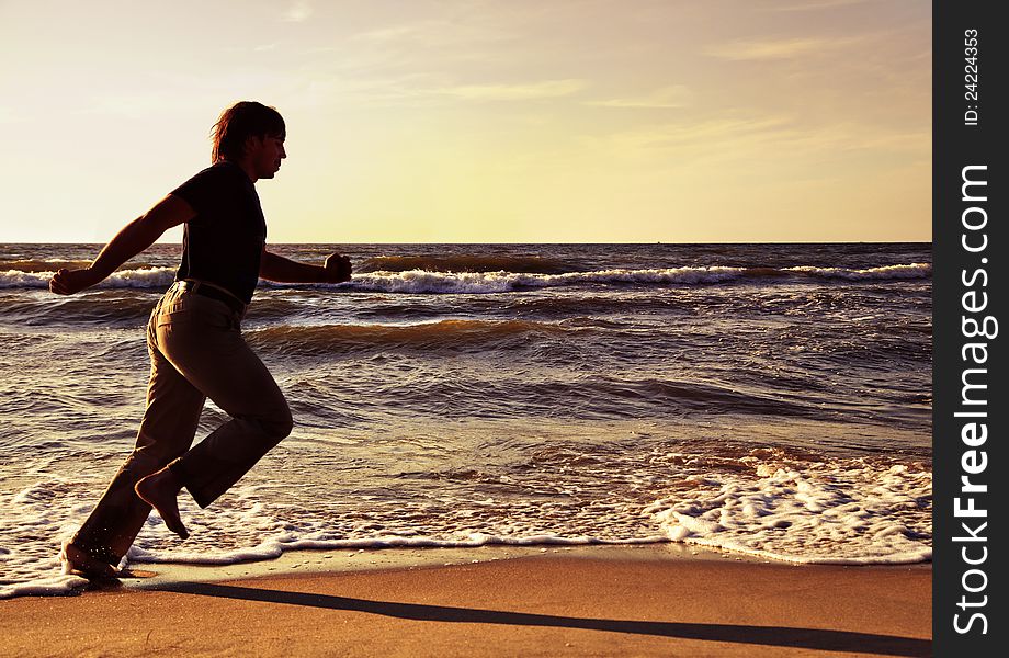 Man running along seashore