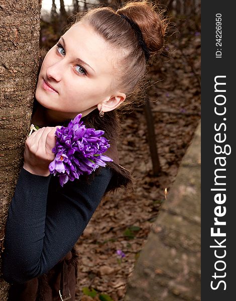 Beautiful girl with snowdrops in a forest