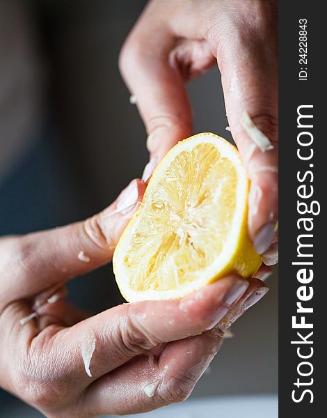 Hand squeezing yellow lemon closeup