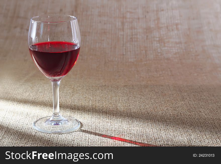 Glass of red wine against a rough sacking