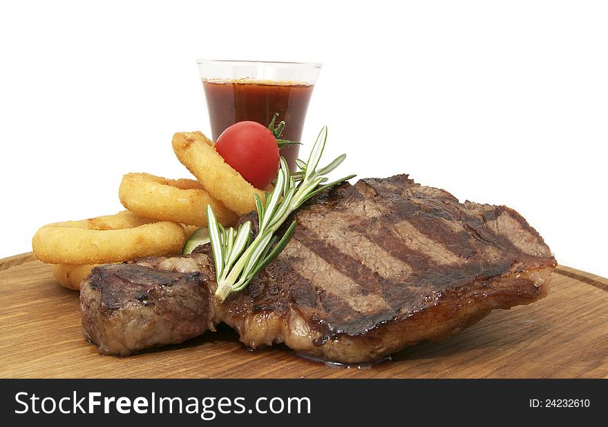 Steak and sauce on a wooden plate over white background