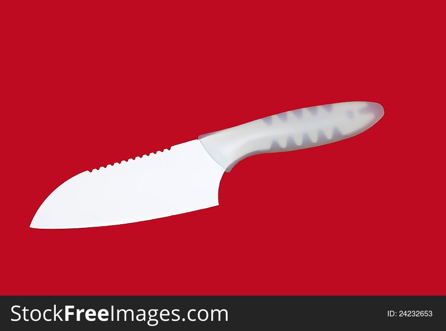 Kitchen knife with a ceramic coating on a red background