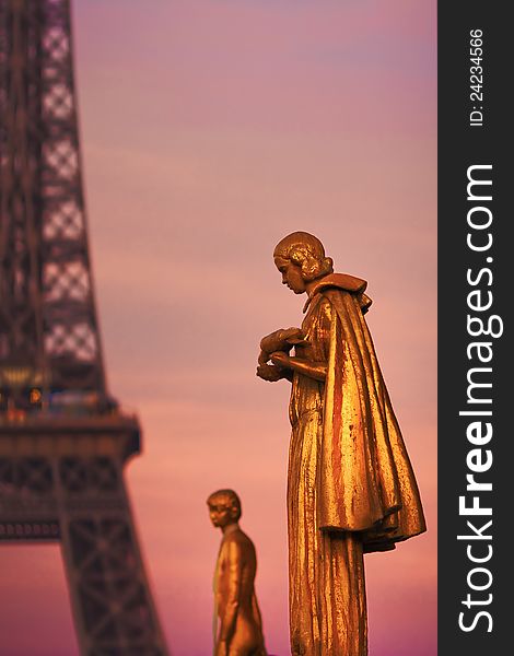 Golden sculptures in front of the Eiffel Tower