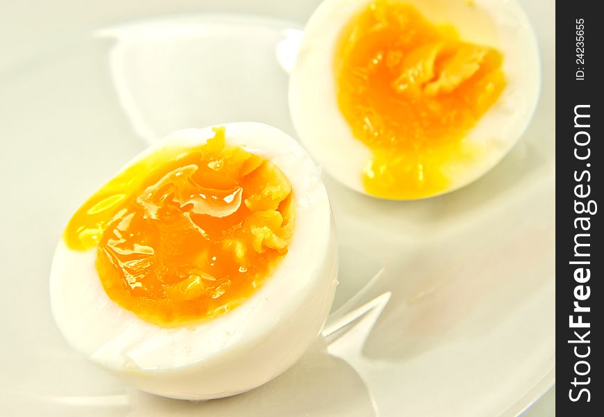 Soft boiled egg, on white plate, in half
