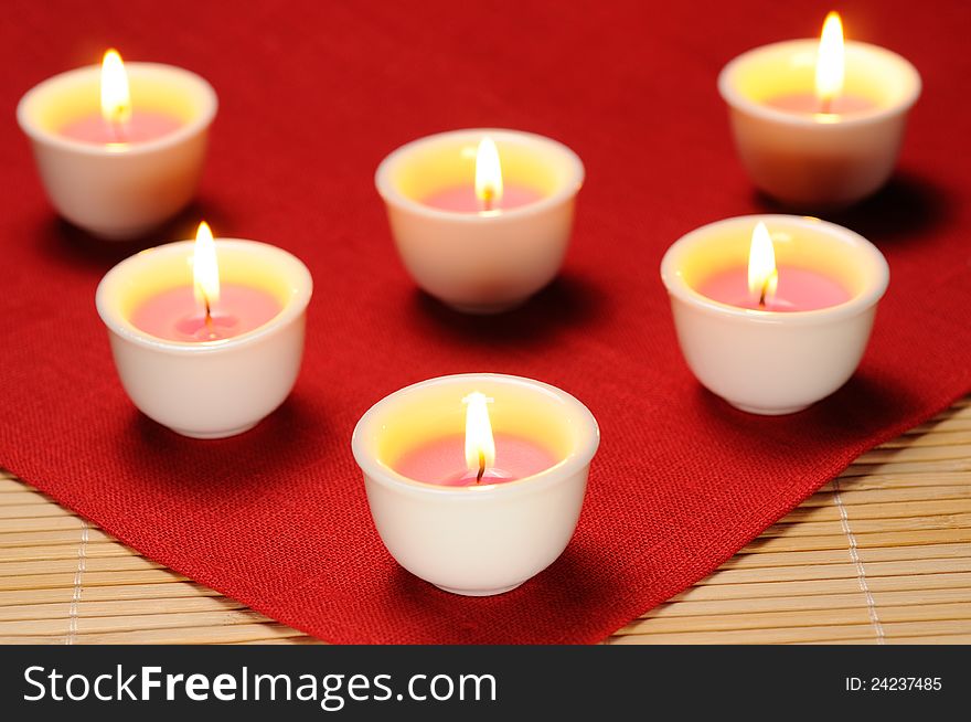 Set of burning candles on red canvas