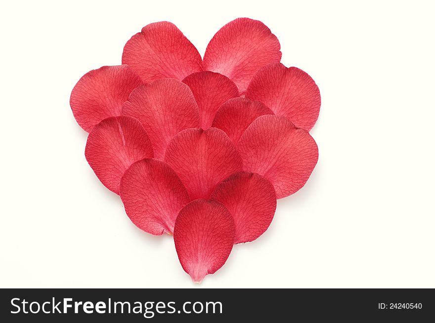 Red petals ordered in heart shape, background. Red petals ordered in heart shape, background