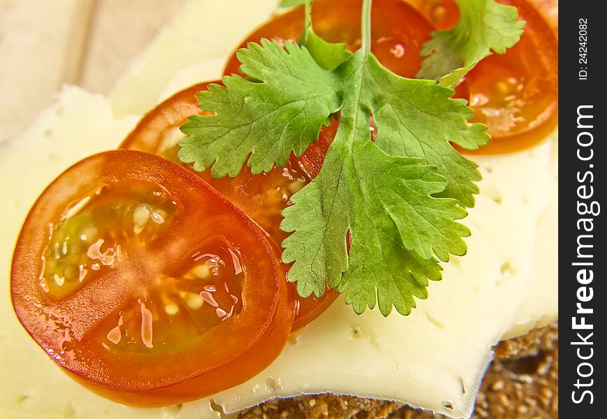 Cracker isolated on wooden plate, with cheese, tomato and parsley. Cracker isolated on wooden plate, with cheese, tomato and parsley