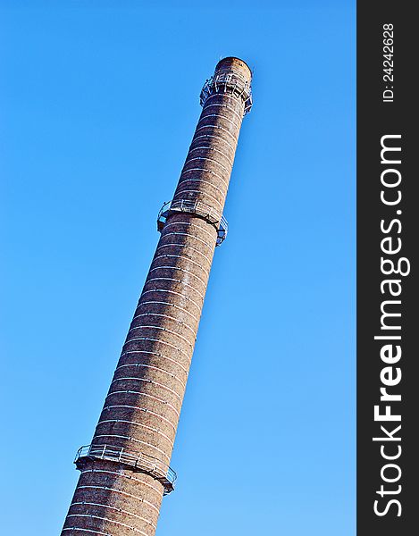 Factory chimney without smoke against clear blue sky