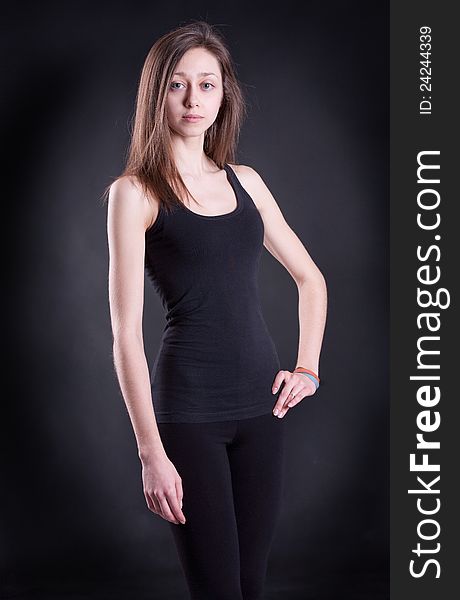 The girl in a black vest on a black background