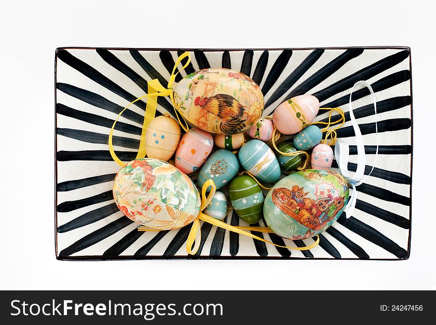 Various colourful easter eggs on a black and white striped plate. Various colourful easter eggs on a black and white striped plate.