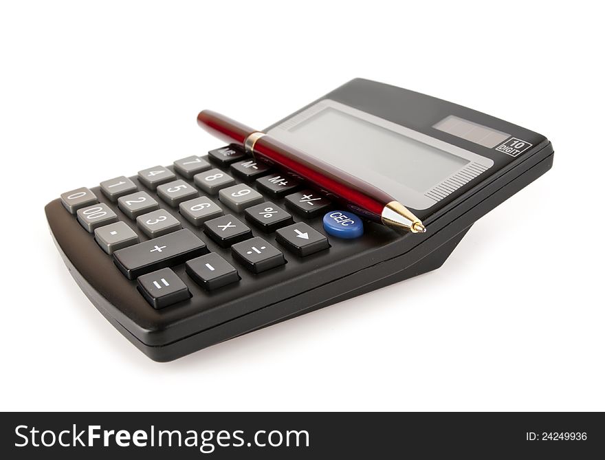 Red pen lies on a black calculator on a white background