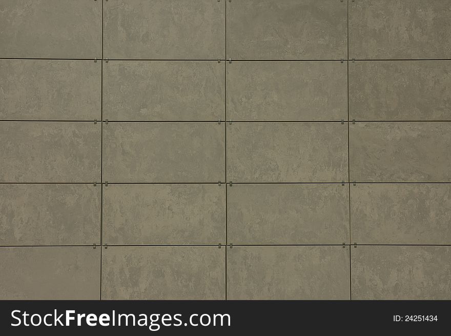 A background with a wall made of a pattern of gray tiles. A background with a wall made of a pattern of gray tiles.