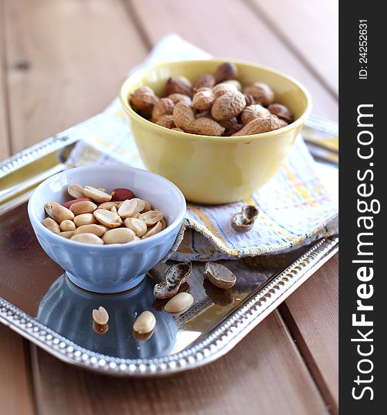 Peanut in a shell and cleared in the bowls on a metal tray