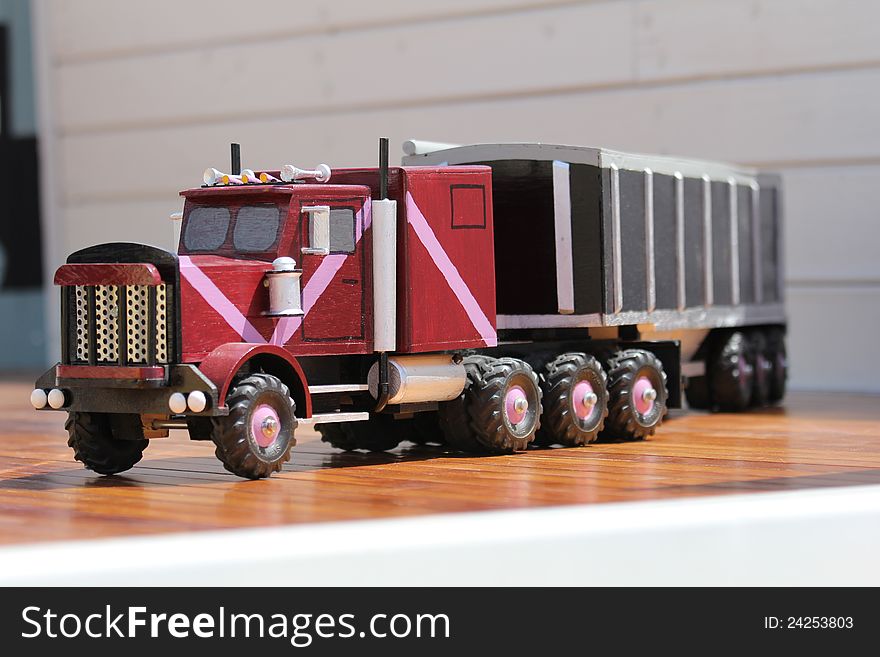 Hand carved wooden semi truck with grain trailer on hardwood floor. Hand carved wooden semi truck with grain trailer on hardwood floor