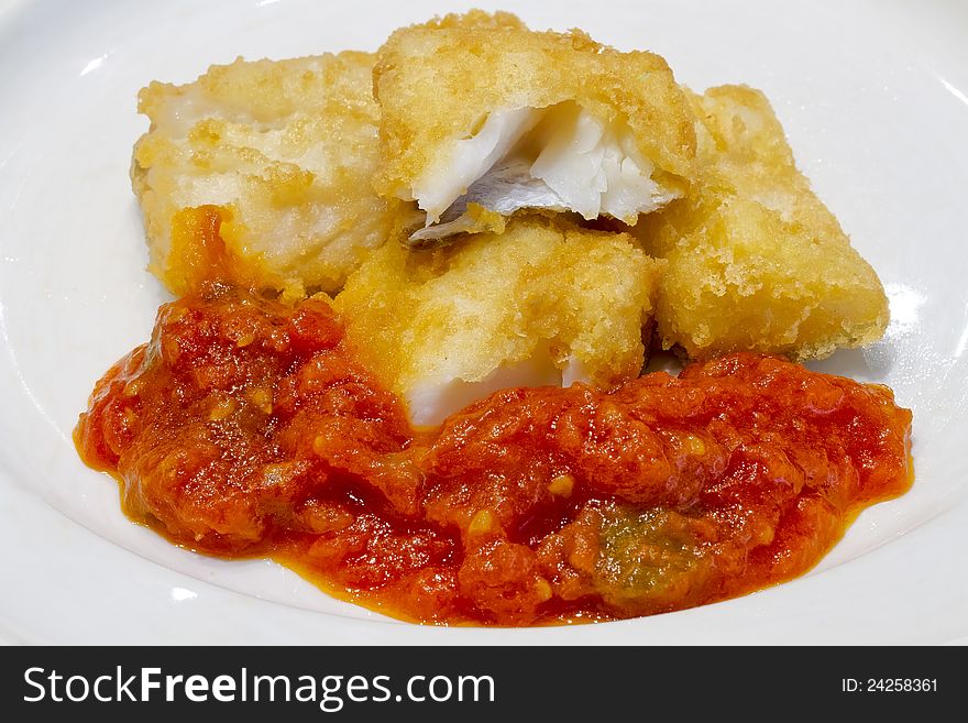 Fried salted codfish ready for a meal, with tomato