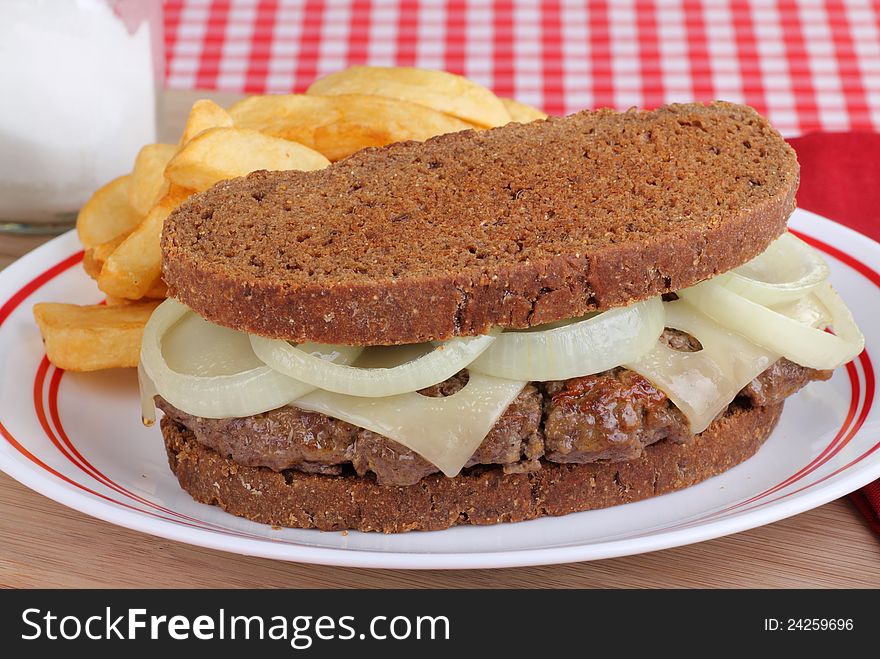 Hamburger with swiss cheese and onion on toasted rye bread. Hamburger with swiss cheese and onion on toasted rye bread