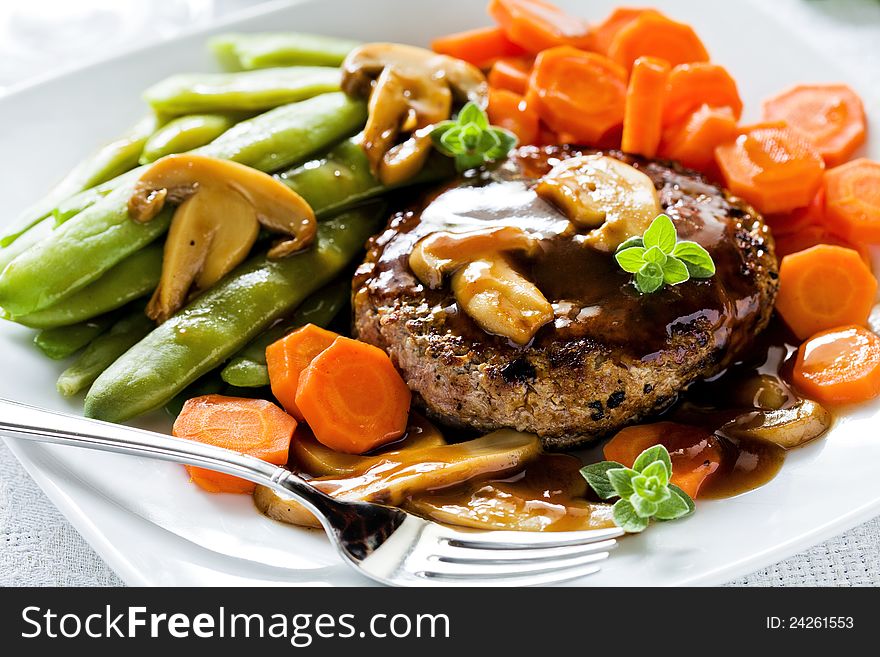Photograph of a tasty dish of burger and vegetables. Photograph of a tasty dish of burger and vegetables