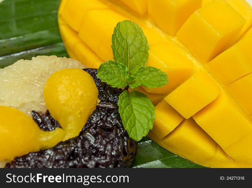 Black and white sticky rice with mango decorate with mint