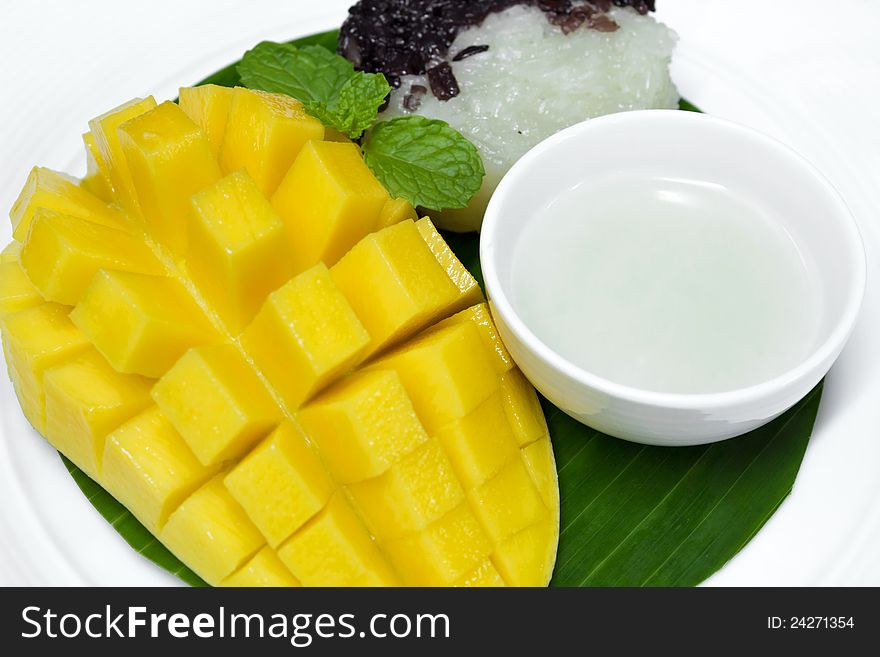 Black and white sticky rice with mango decorate with mint