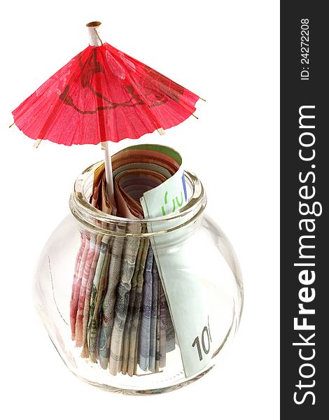 A glass jar contains money : paper currency with red umbrella, isolated on white - Saving for the rainy day
