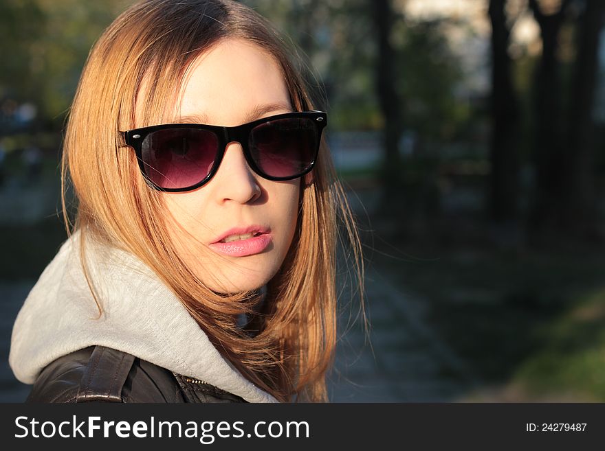 Young girl with sunglasses, outdoors. Face close-up. Young girl with sunglasses, outdoors. Face close-up.