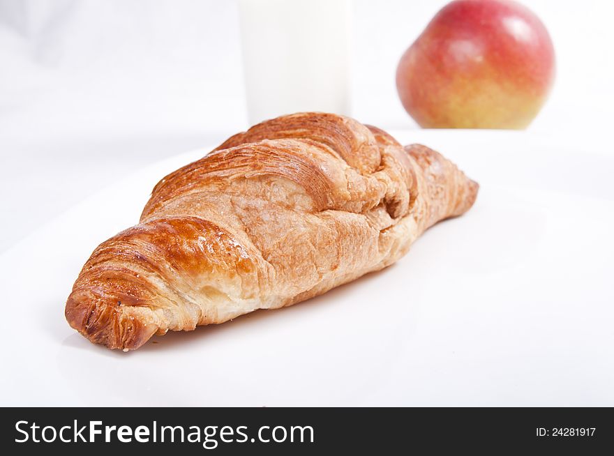 French croissant with apple on light background