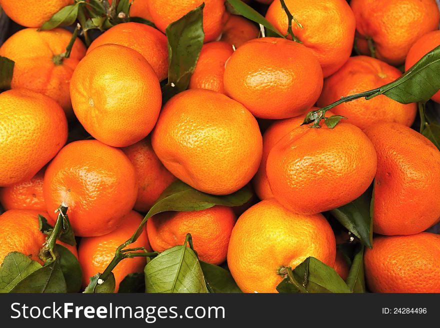 Heaps of tangerines with leaves