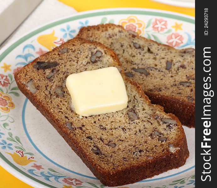 Slice of nut bread with butter on a plate. Slice of nut bread with butter on a plate
