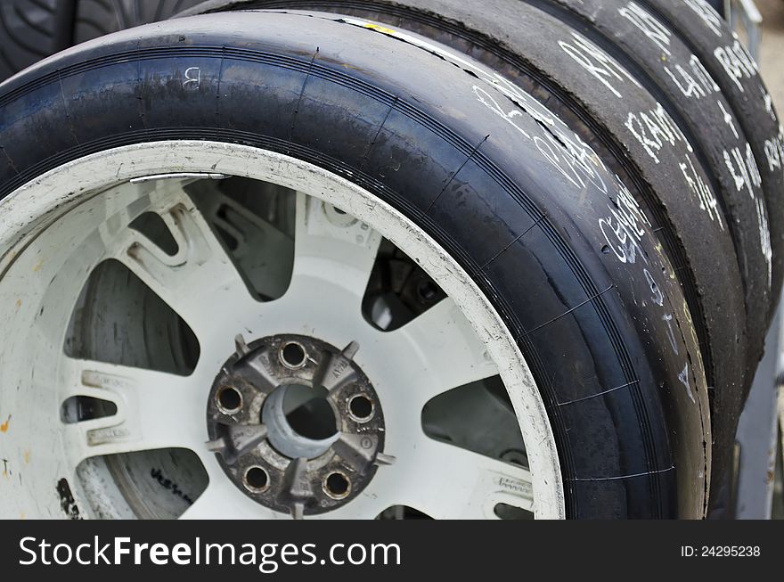 Racing slick tires lined up on a rack. Racing slick tires lined up on a rack