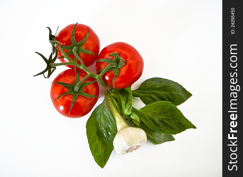 fresh basil, tomatoes and garlic on a white background. fresh basil, tomatoes and garlic on a white background