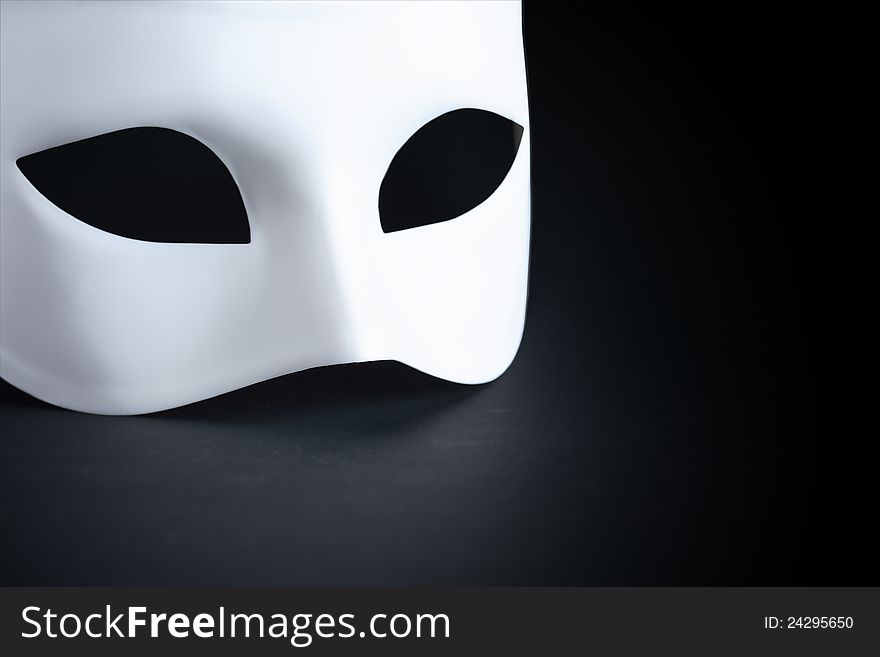 Art concept. Closeup of white mask on black background with free space for text