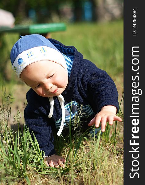 Baby crawls on the grass in spring