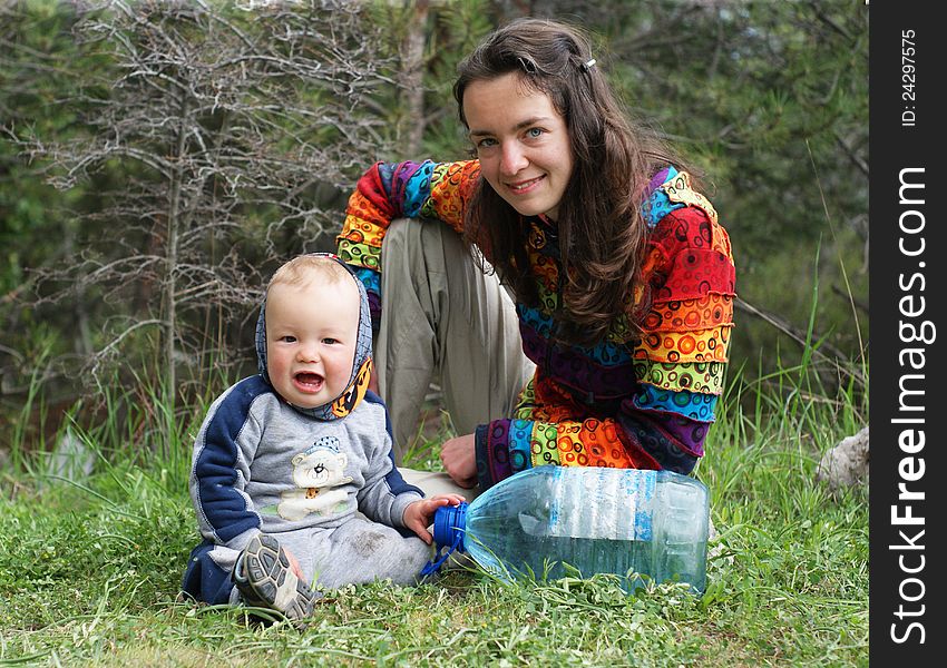 Mother and baby sit on the grass on the nature. Mother and baby sit on the grass on the nature