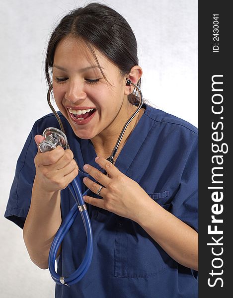 A beautiful female medical healthcare nurse wearing scrubs and a stethoscope, and having a fun attitude.