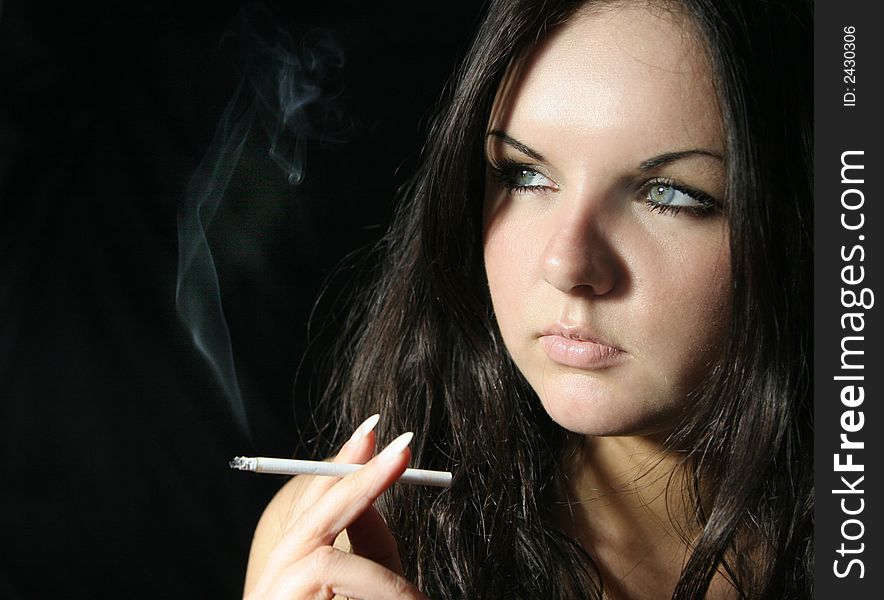 Young girl in black top with cigarette. Young girl in black top with cigarette