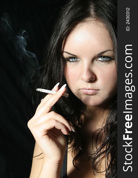 Young girl in black top with cigarette. Young girl in black top with cigarette