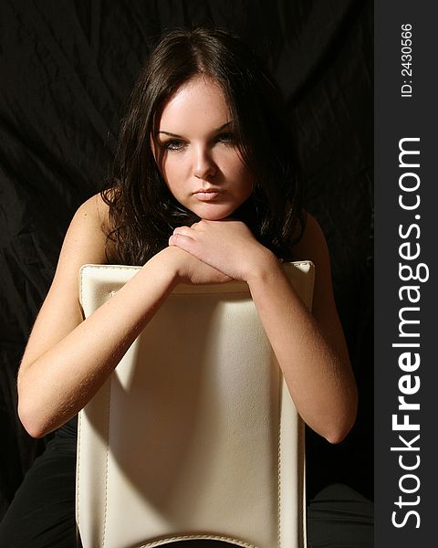 Young girl in black top on the chair. Young girl in black top on the chair