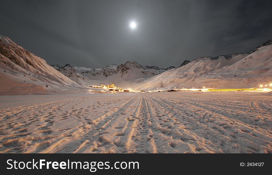 A night shot of a French alpine town surrounded by snowy mountains. A night shot of a French alpine town surrounded by snowy mountains
