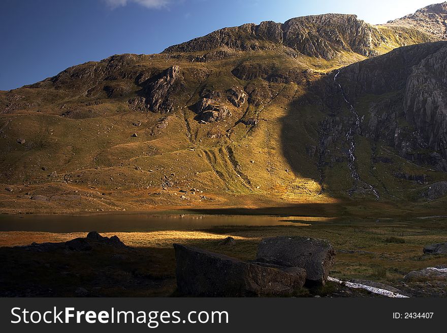 Llyn Idwal in the Snowdonia National Park bathed in golden sunlight. Llyn Idwal in the Snowdonia National Park bathed in golden sunlight.