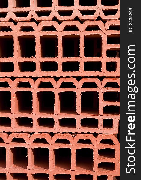 Stacked bright red bricks with holes - for background. Stacked bright red bricks with holes - for background