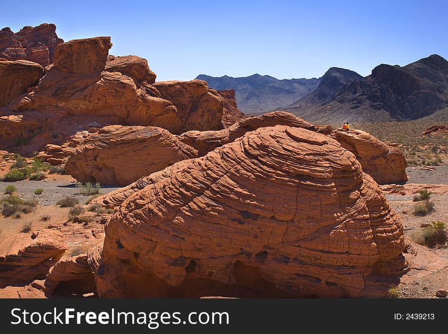 Couple sitting on rocks in the desert enjoying the view. Couple sitting on rocks in the desert enjoying the view