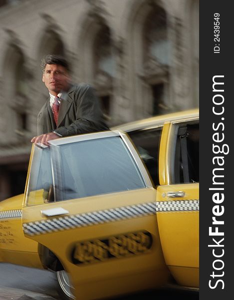 Businessman getting out of a yellow taxi cab. Businessman getting out of a yellow taxi cab